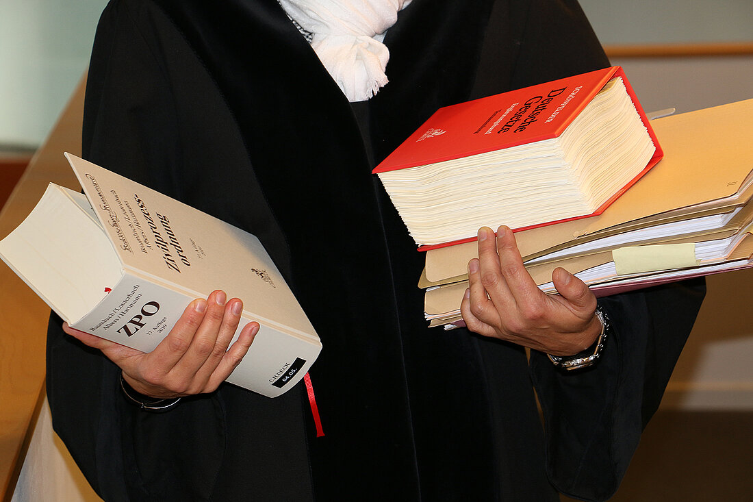 Richter in Robe mit Gesetzestexten