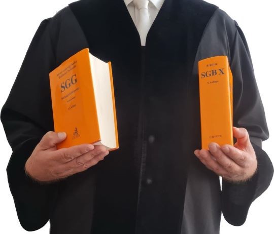 Richter in Robe Gesetzbücher haltend